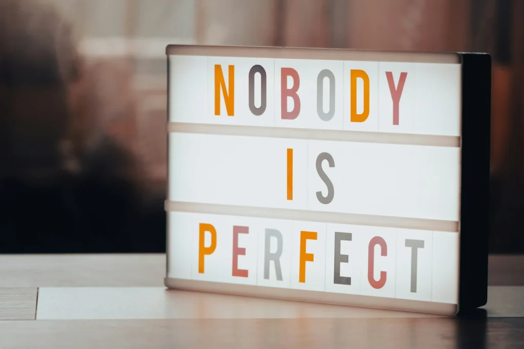 A stock image of a sign showing NOBODY IS PERFECT