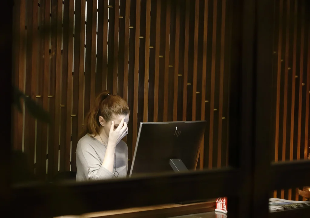 A woman looking at her computer, frustrated.